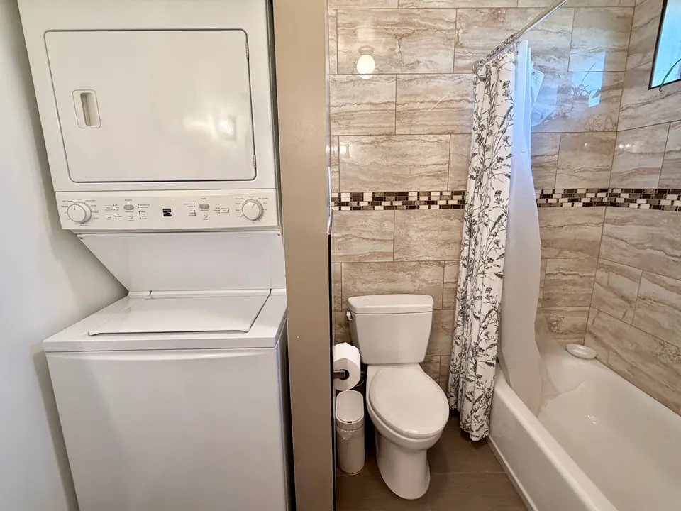 Stacked washer and dryer next to the tub