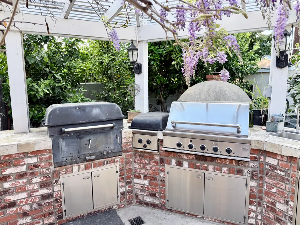 Shared gas and charcoal BBQ grills under the pergola