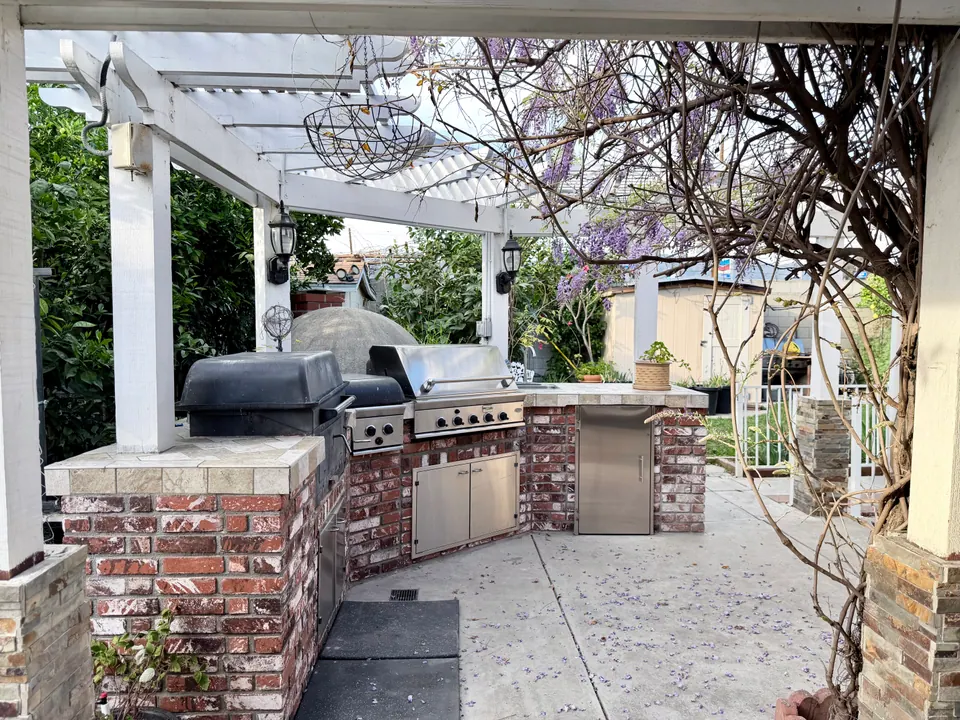 Outdoor kitchen with grills and wisteria